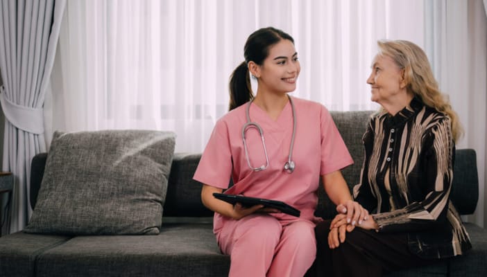 Nurse and resident chatting in a cozy common area