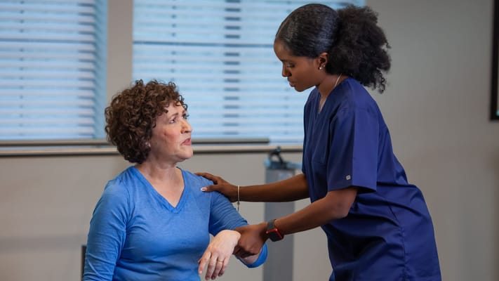 A staff member assisting a resident during therapy
