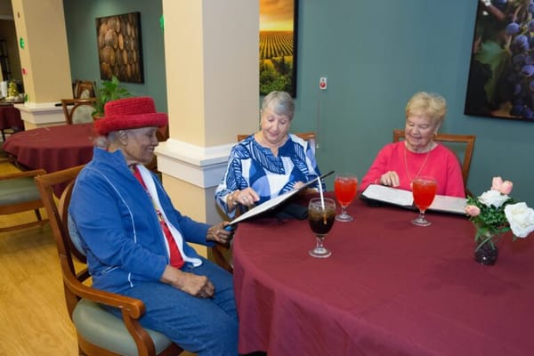 Residents enjoying drinks and reading menus in a dining area