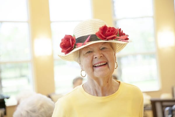 A smiling resident wearing a decorated hat