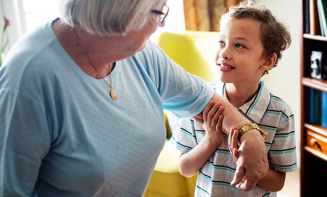 A senior woman interacting with a young boy in a cozy room