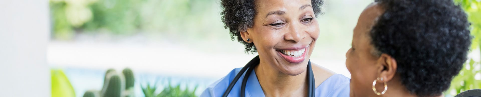 A caregiver smiling with a resident outdoors