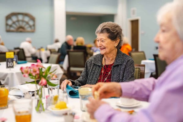 Residents enjoying a meal together in the dining room