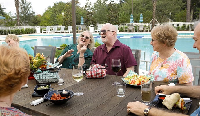 Residents enjoying a meal by the poolside.