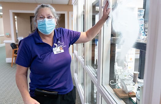 Staff member cleaning a display case in common area