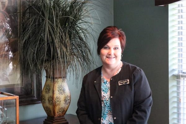 Staff member smiling in a well-decorated room