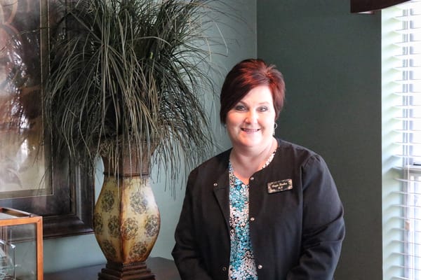 Staff member smiling in a well-decorated room