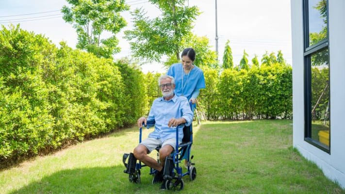 Caregiver assisting a resident in a garden area