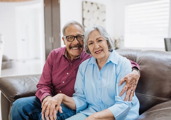 Happy senior couple sitting together on a couch