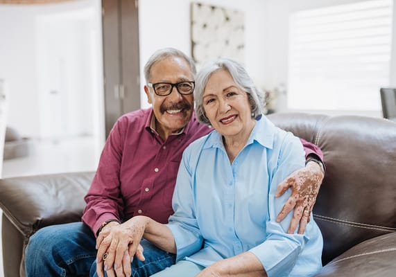 Happy senior couple sitting together on a couch