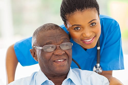 Nurse with elderly resident smiling warmly together
