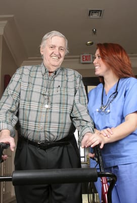 A male resident and female staff member smiling together
