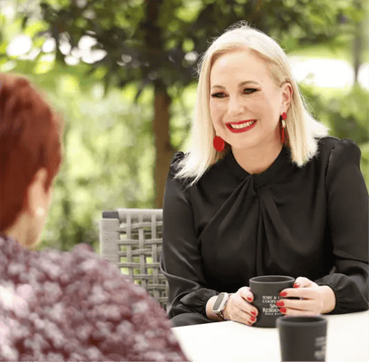A smiling staff member engages with a resident outdoors.