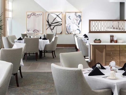 Elegant dining room with set tables and artworks