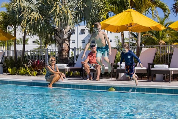 Residents enjoying time at the pool with sun umbrellas