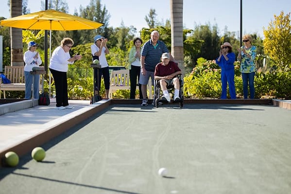 Residents playing bocce ball in an outdoor space