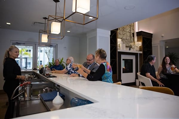 Residents socializing in a common area with a bar