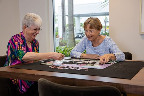 Two residents enjoying a puzzle together indoors