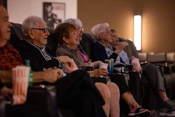 Residents enjoying a movie in a cozy theater room