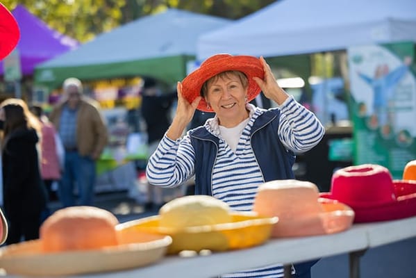 Resident enjoying a colorful hat at an outdoor event