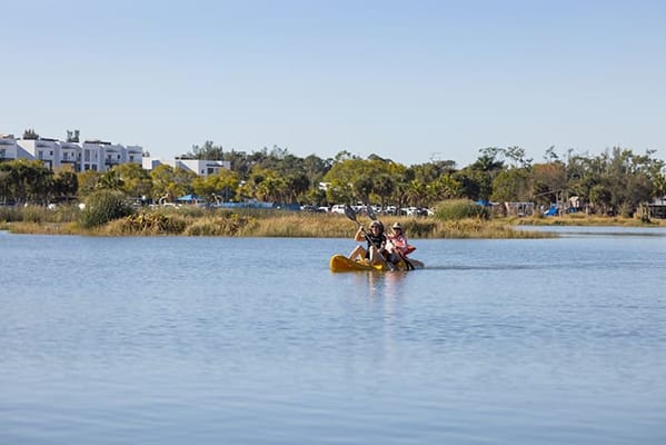 Two residents kayaking on a calm lake