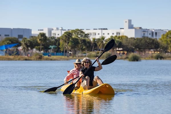 Residents kayaking on a sunny day at the facility's lake