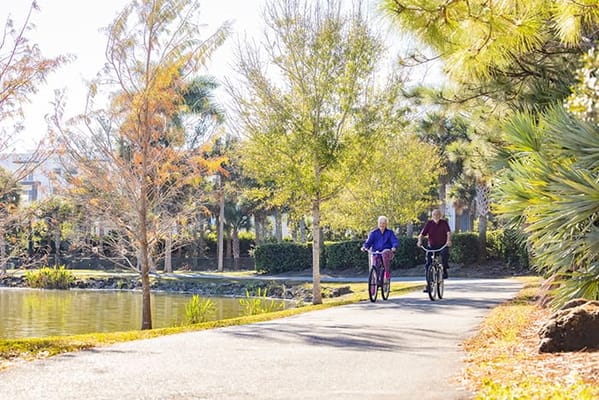 Residents biking along a scenic pathway near water