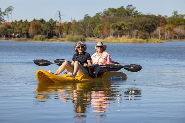 Two women kayaking on a serene lake