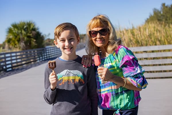 Senior resident and a child enjoying popsicles outdoors