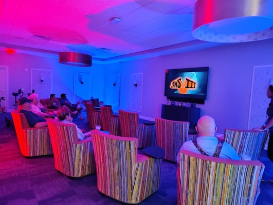 Residents watching a movie in a cozy lounge.
