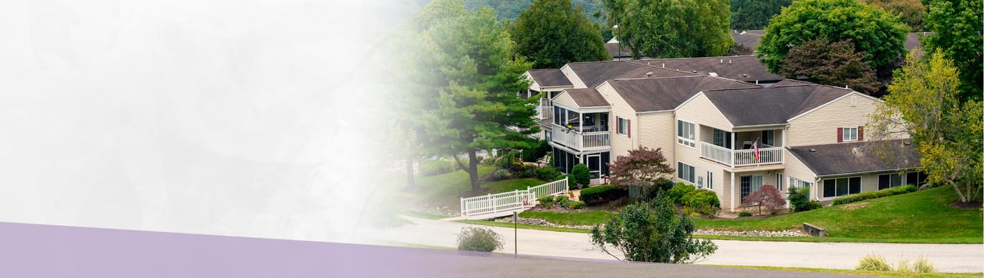 A picturesque view of senior living buildings surrounded by greenery