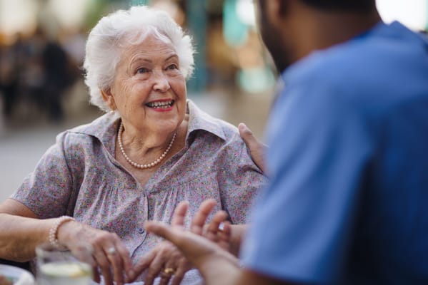 Resident interacting with staff in a lively outdoor setting