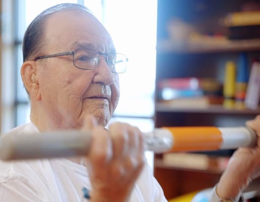Elderly man exercising indoors with weights