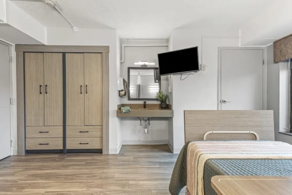 A private resident room with furnishings and a TV