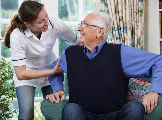 Staff assisting a resident in a cozy common area