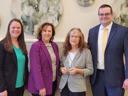 Staff presenting an award to a resident in a common area