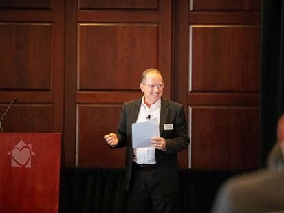 A man speaking at a podium in a conference room