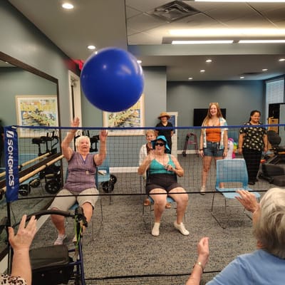 Residents playing balloon volleyball in a common area
