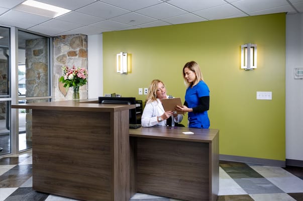Staff assisting a resident at the reception area