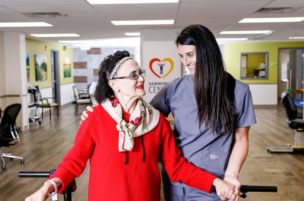 Staff assisting a resident in a rehabilitation space