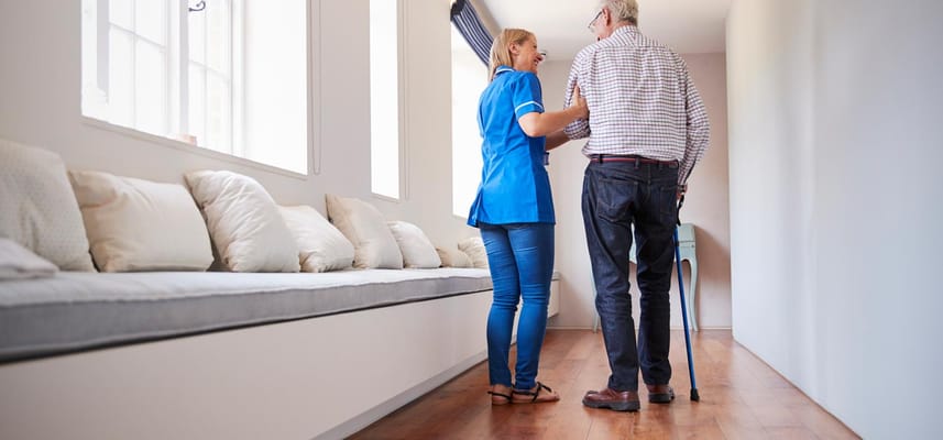 A staff member assisting a resident in a hallway