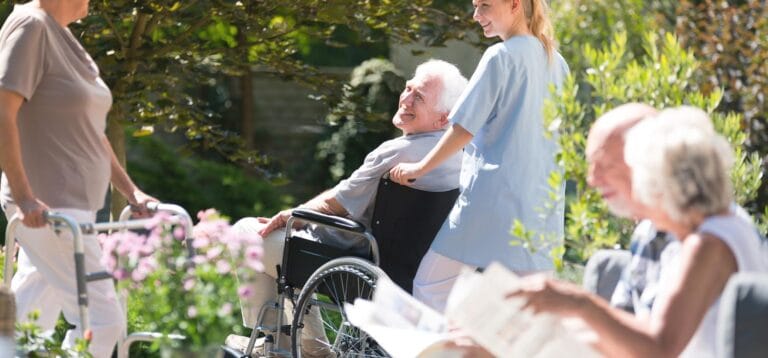Residents enjoying time in the garden with staff assistance