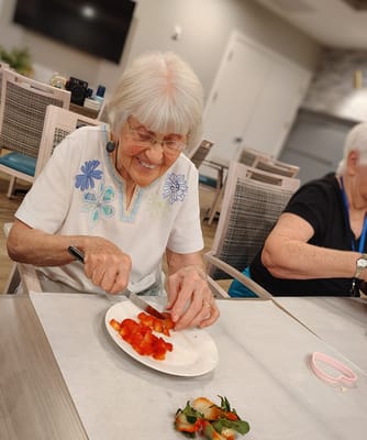 Resident enjoying a cooking activity with strawberries