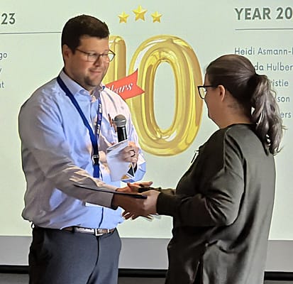 Staff member presenting award at a celebration event