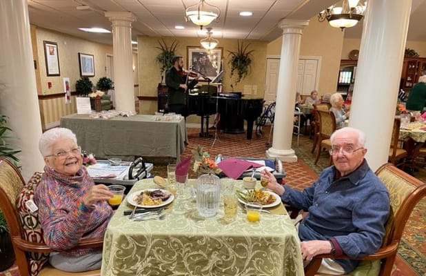 Residents enjoying lunch with live music in the dining area.