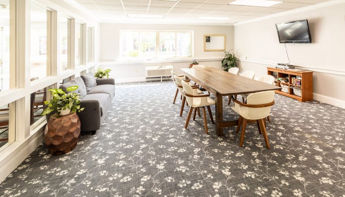 Bright and spacious common area with seating and a dining table