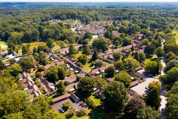 Aerial view of a senior living campus surrounded by trees