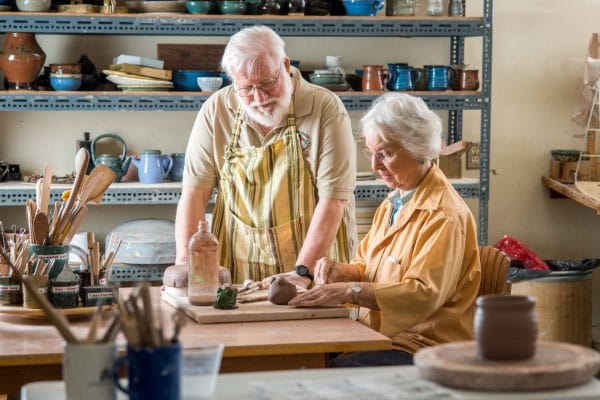 Residents engaging in pottery activity inside a studio