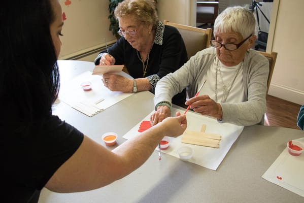 Residents engaged in a painting activity at a table