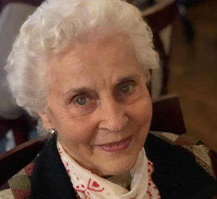 A senior woman smiling warmly at the camera
